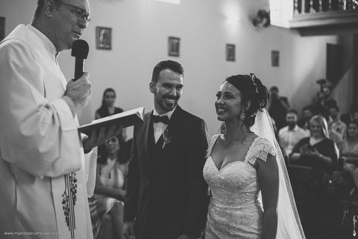 noivos sorrindo para o padre