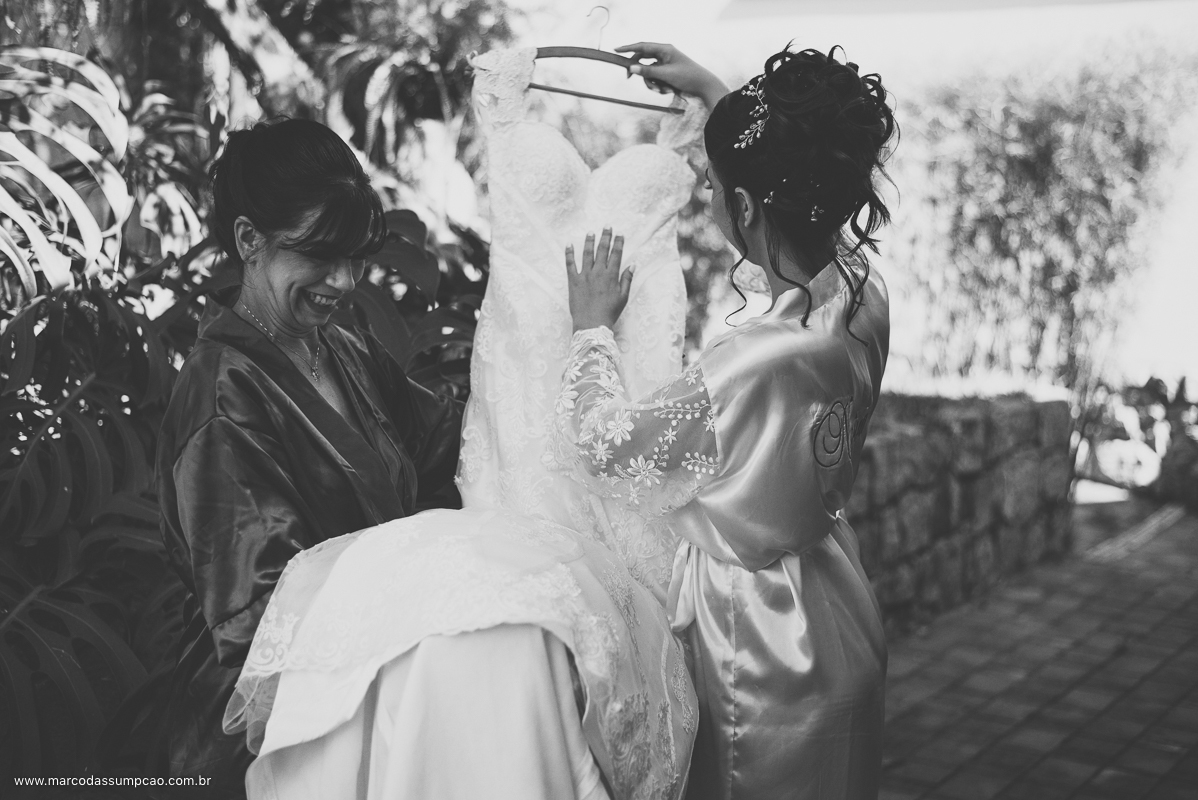 mae e noiva segurando vestido de casamento