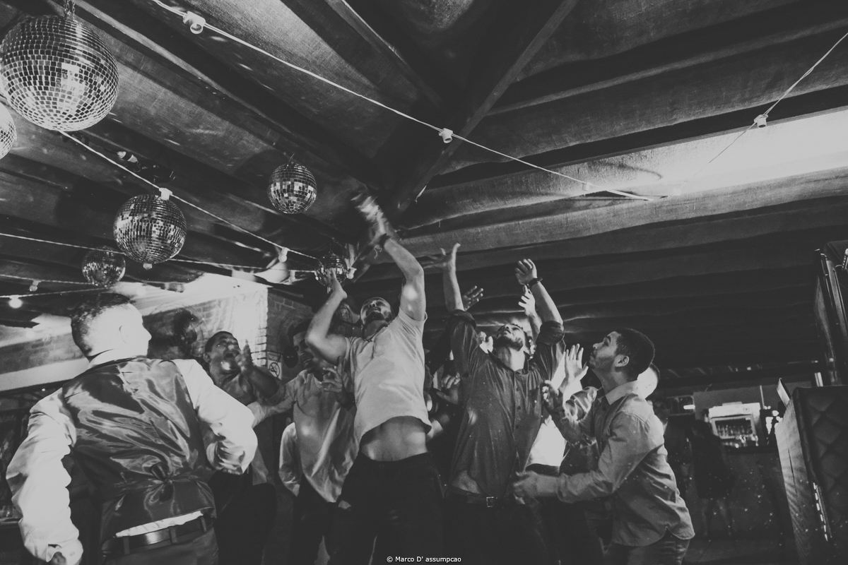 homens pulando para pegar oa garrafa de bebida