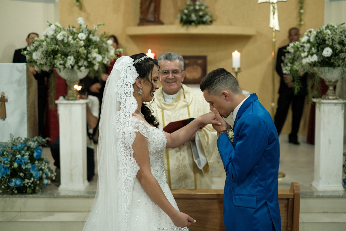 noivo beijando a mao da noiva no altar