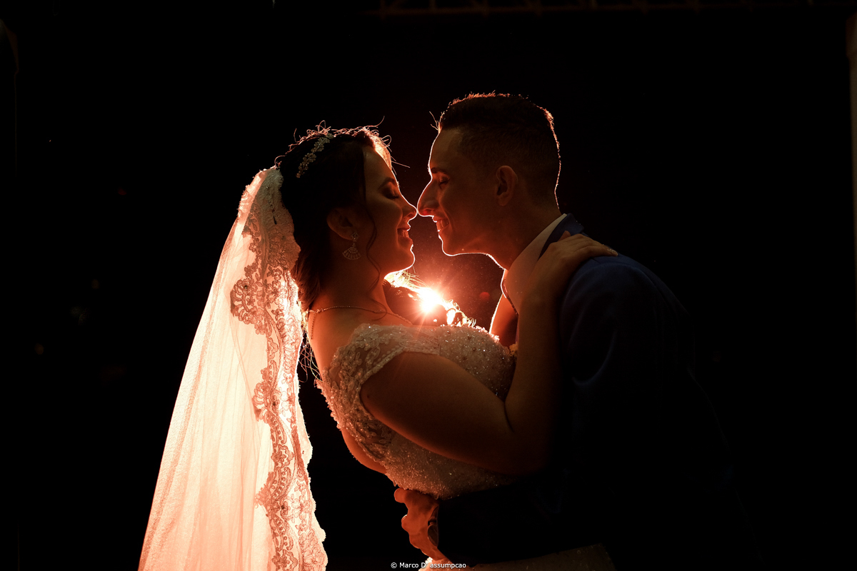 noivos se beijando com luzes de flash por tras