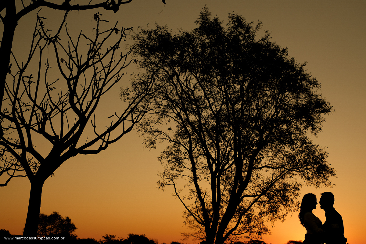 casal em foto de silhueta com por do sol amarelo ao fundo