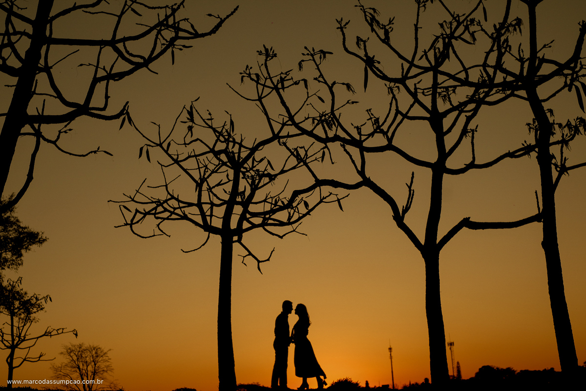 casal em foto de silhueta com por do sol amarelo ao fundo