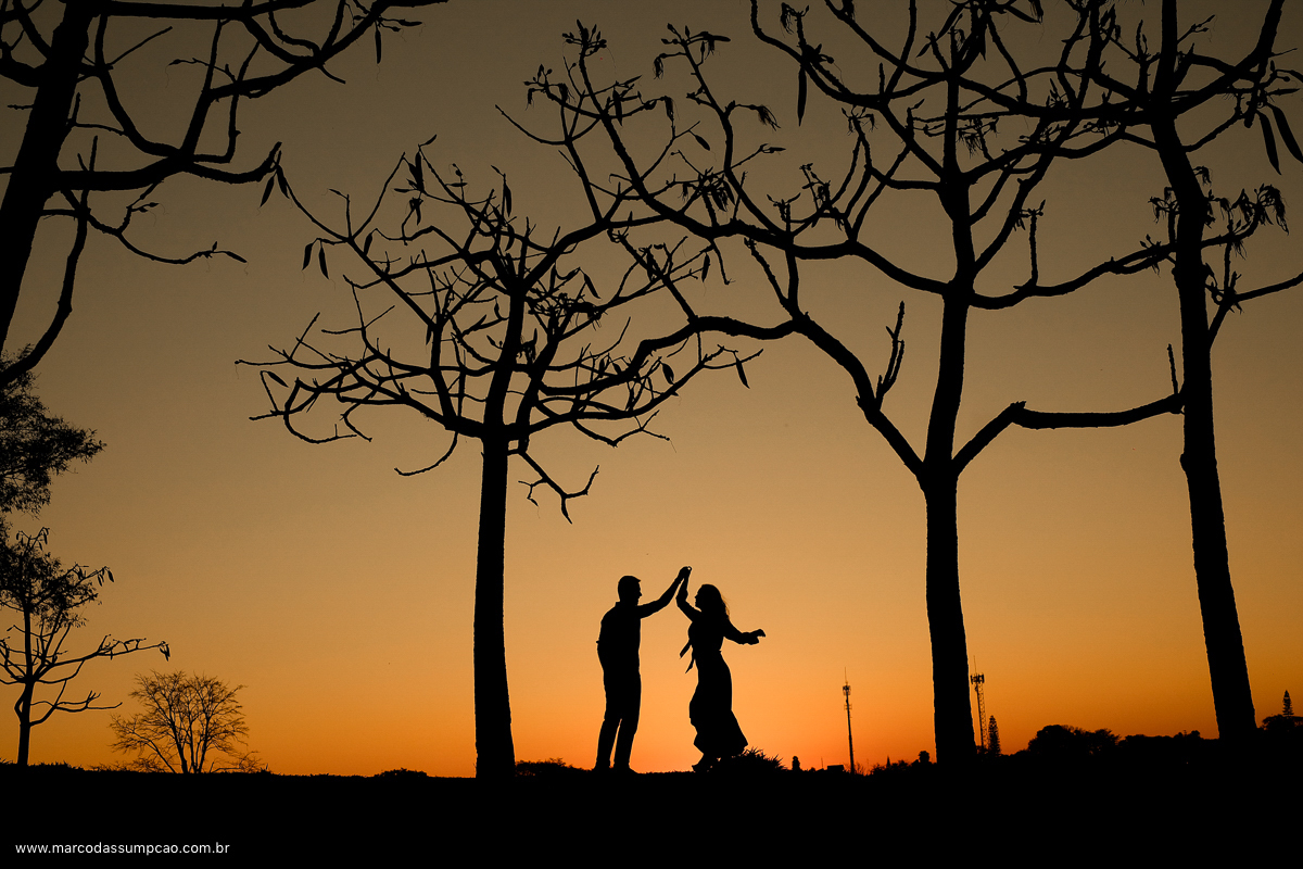 casal em foto de silhueta com por do sol amarelo ao fundo