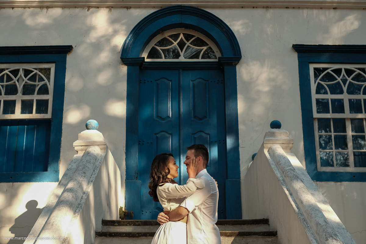 casal se abracando em frente a casarao antigo