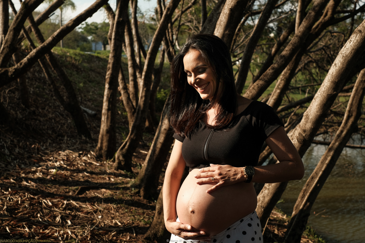 gestante acarinhando a sua barriga em meio a natureza
