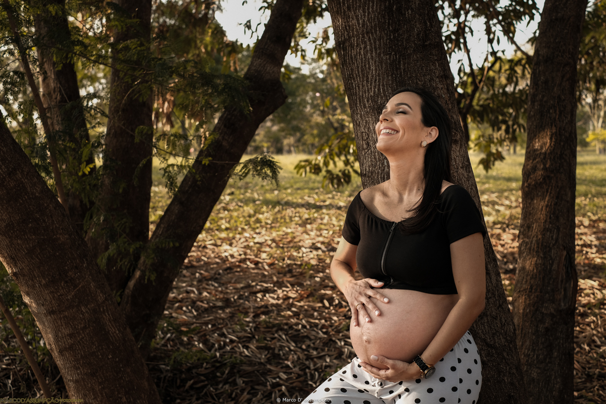 gestante acarinhando a sua barriga em meio a natureza