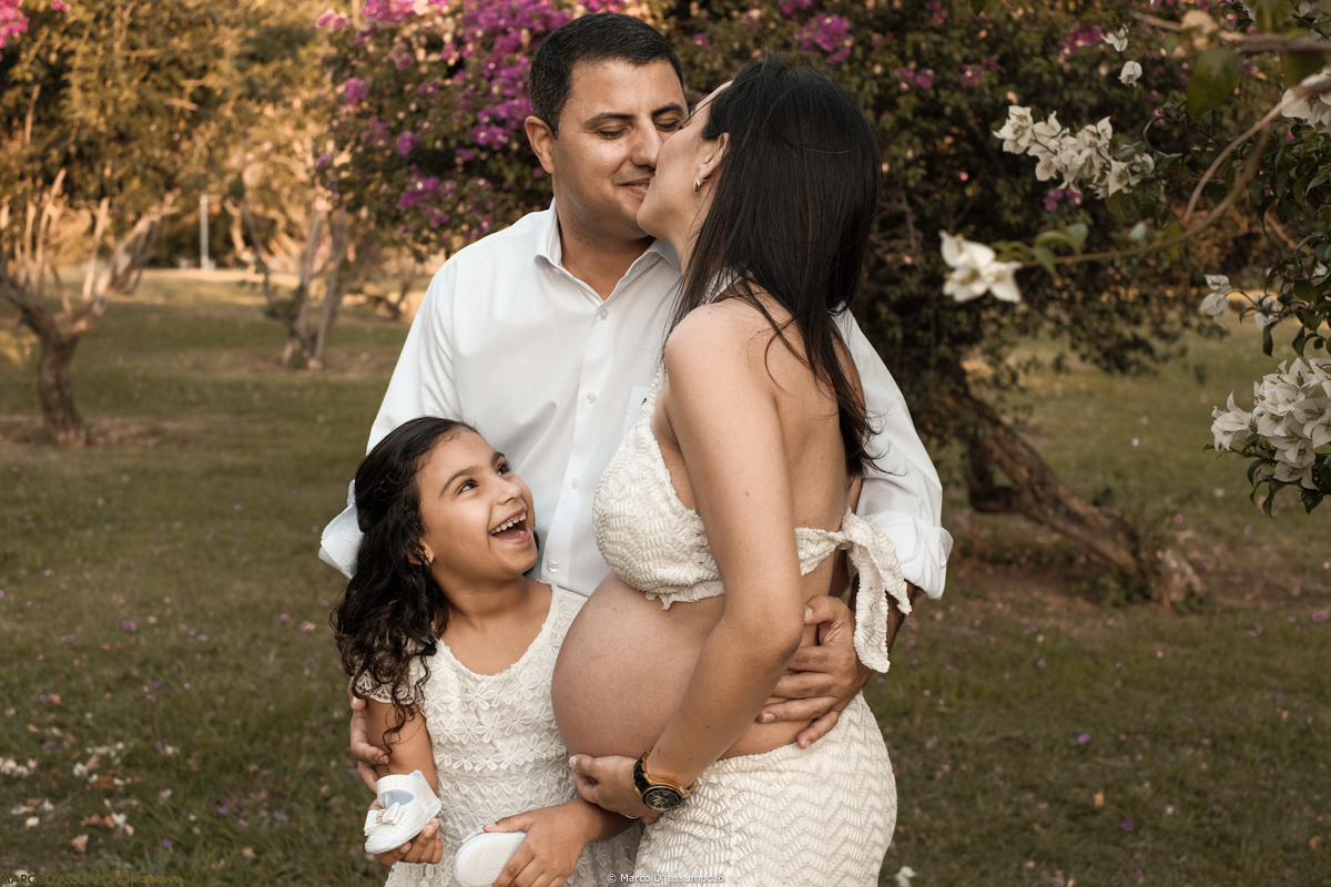 crianca dando risada ao ver os pais se beijando