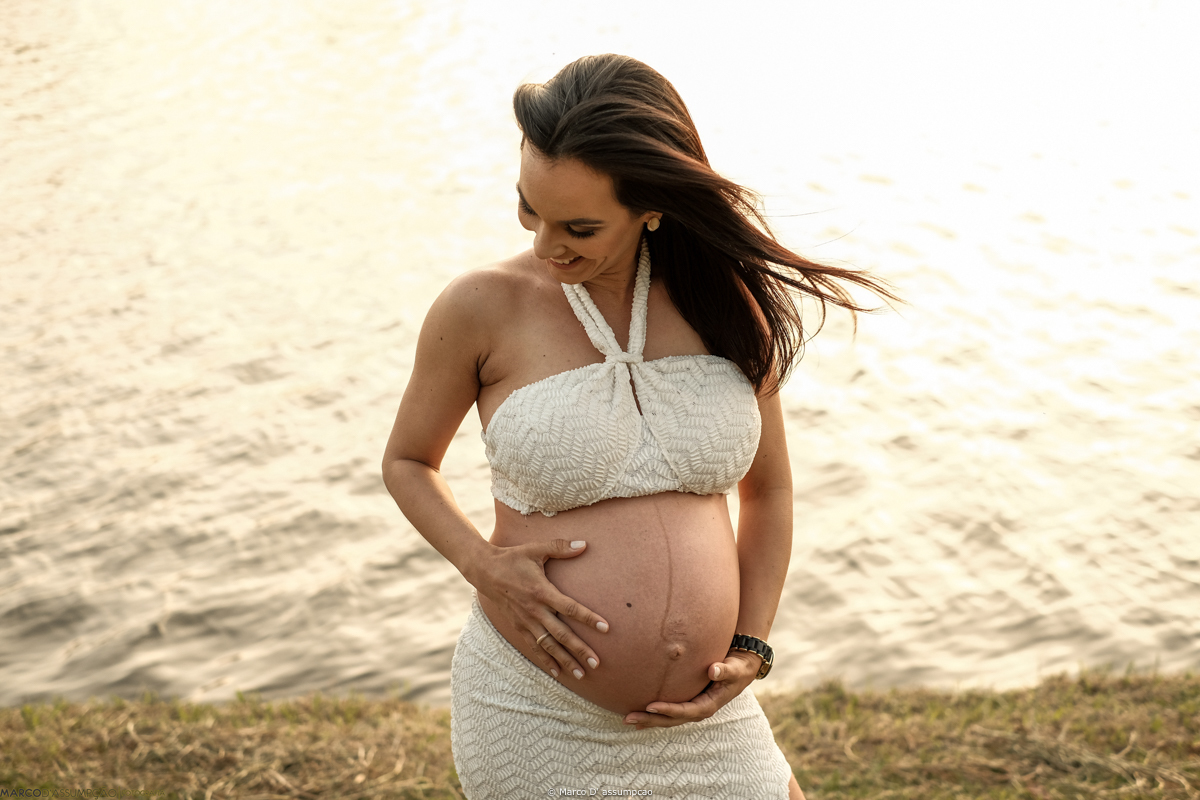gestante acarinhando a sua barriga em meio a natureza