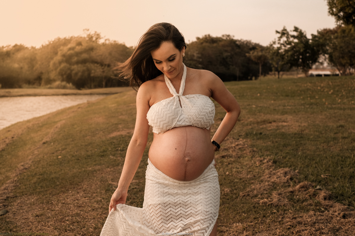 gestante acarinhando a sua barriga em meio a natureza