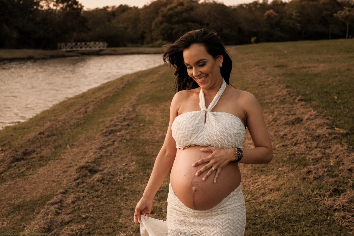 gestante acarinhando a sua barriga em meio a natureza