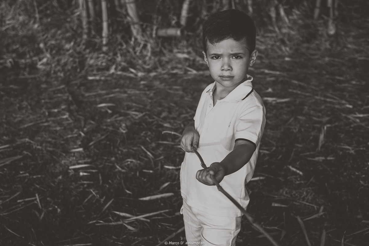 crianca segurando um galho com cara de brava