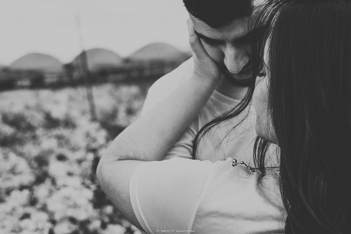 casal se acariciando no meio das flores