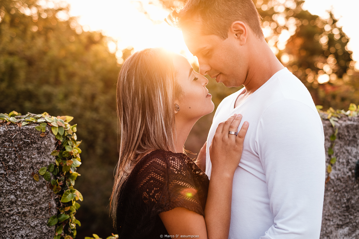 noiva fazendo carinho no rosto do noivo com a luz do sol refletindo no rosto