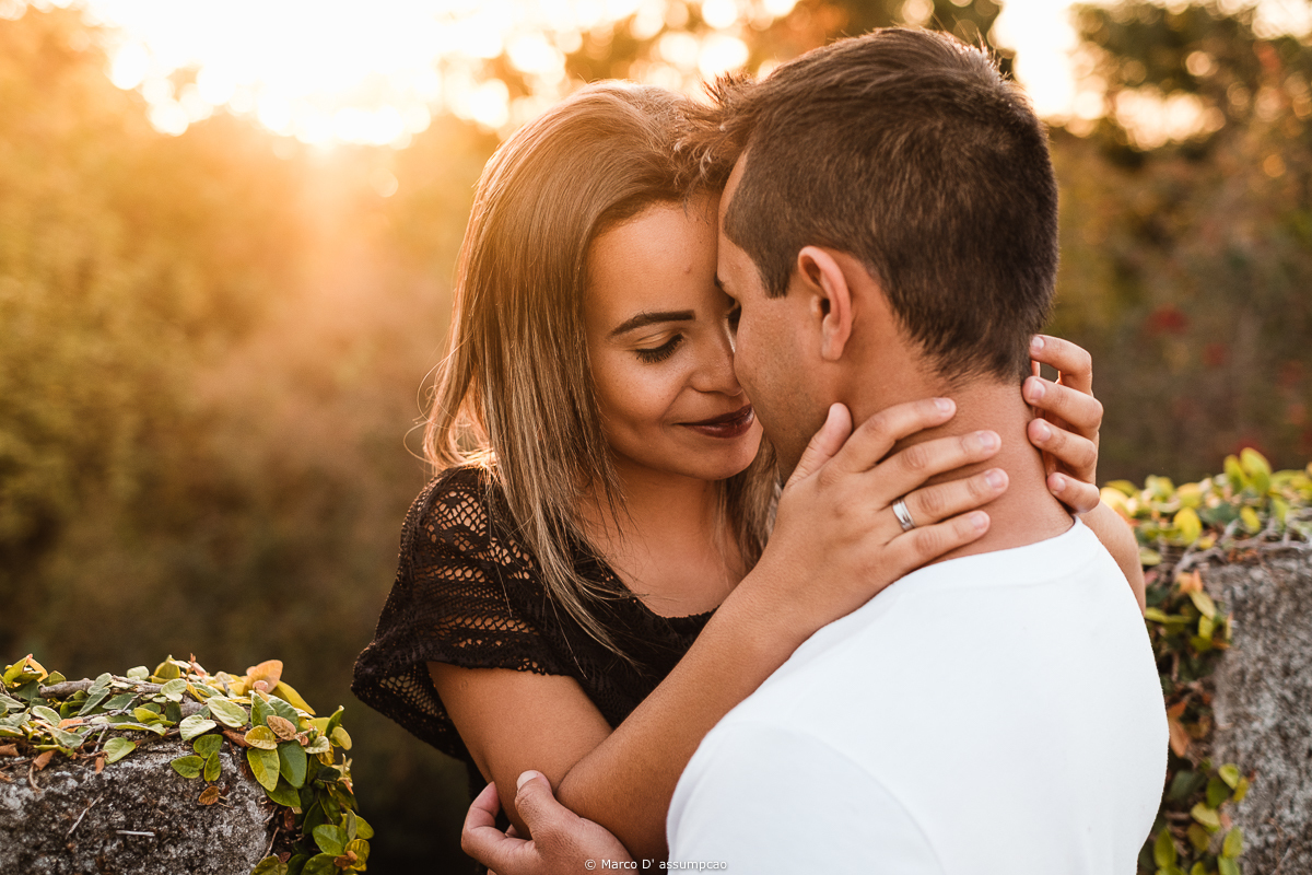noiva fazendo carinho no rosto do noivo com a luz do sol refletindo no rosto