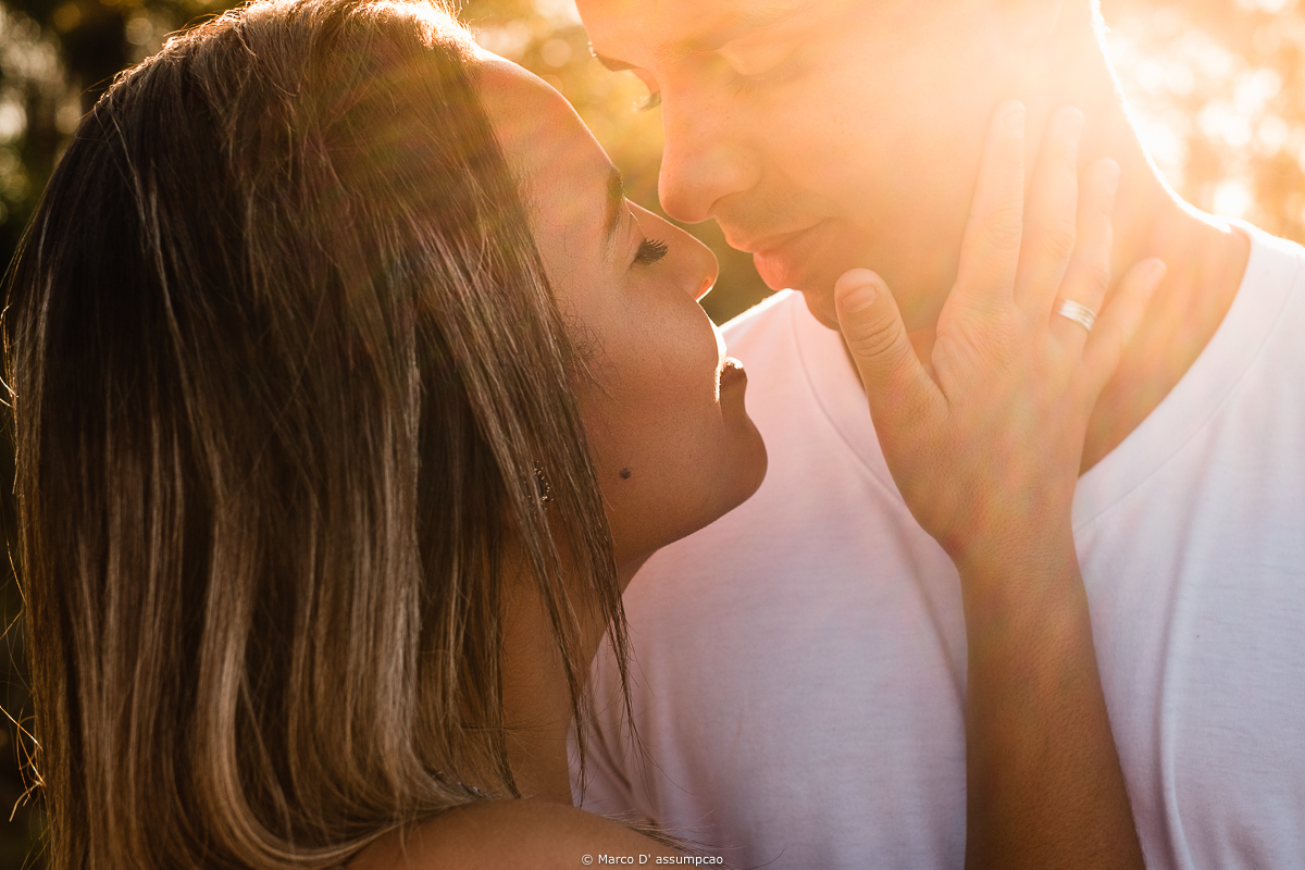 noiva fazendo carinho no rosto do noivo com a luz do sol refletindo no rosto