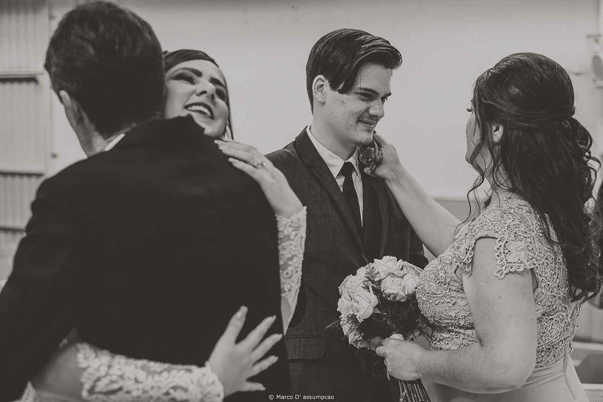 noivos sendo abracados pelos pais