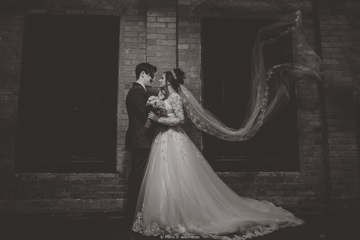 noivos se olhando com veu ao vento