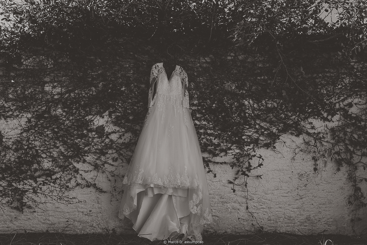 vestido da noiva pendurado na parede com flores