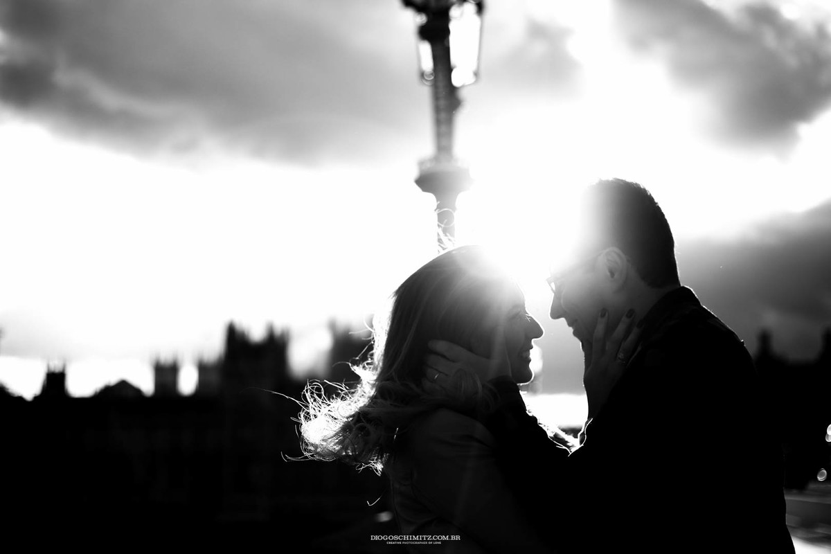 Casal gentilmente segurando o rosto um do outro.