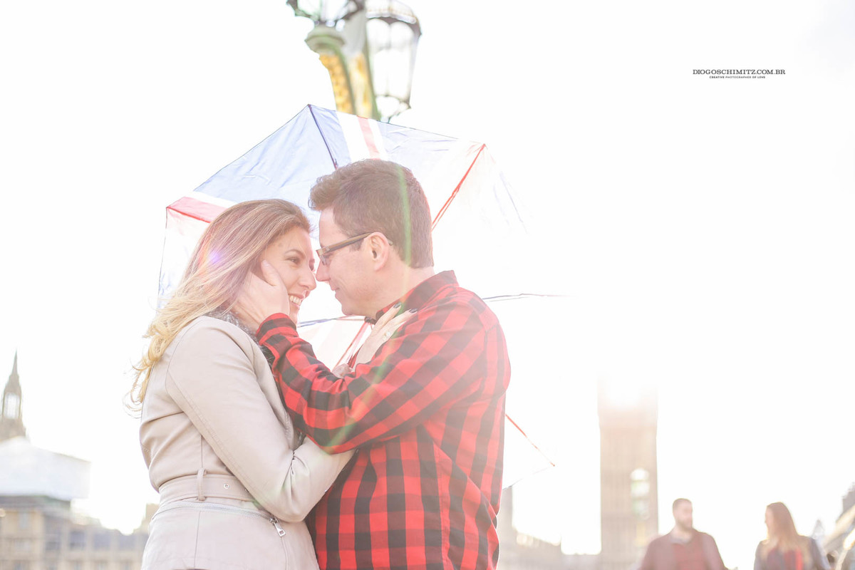 Homem delicadamente segurando o rosto da mulher enquanto ela sorri.
