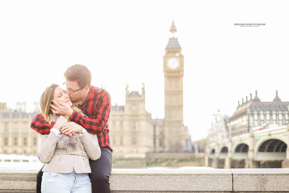 Casal se beijando em frente ao Palácio de Westminster.