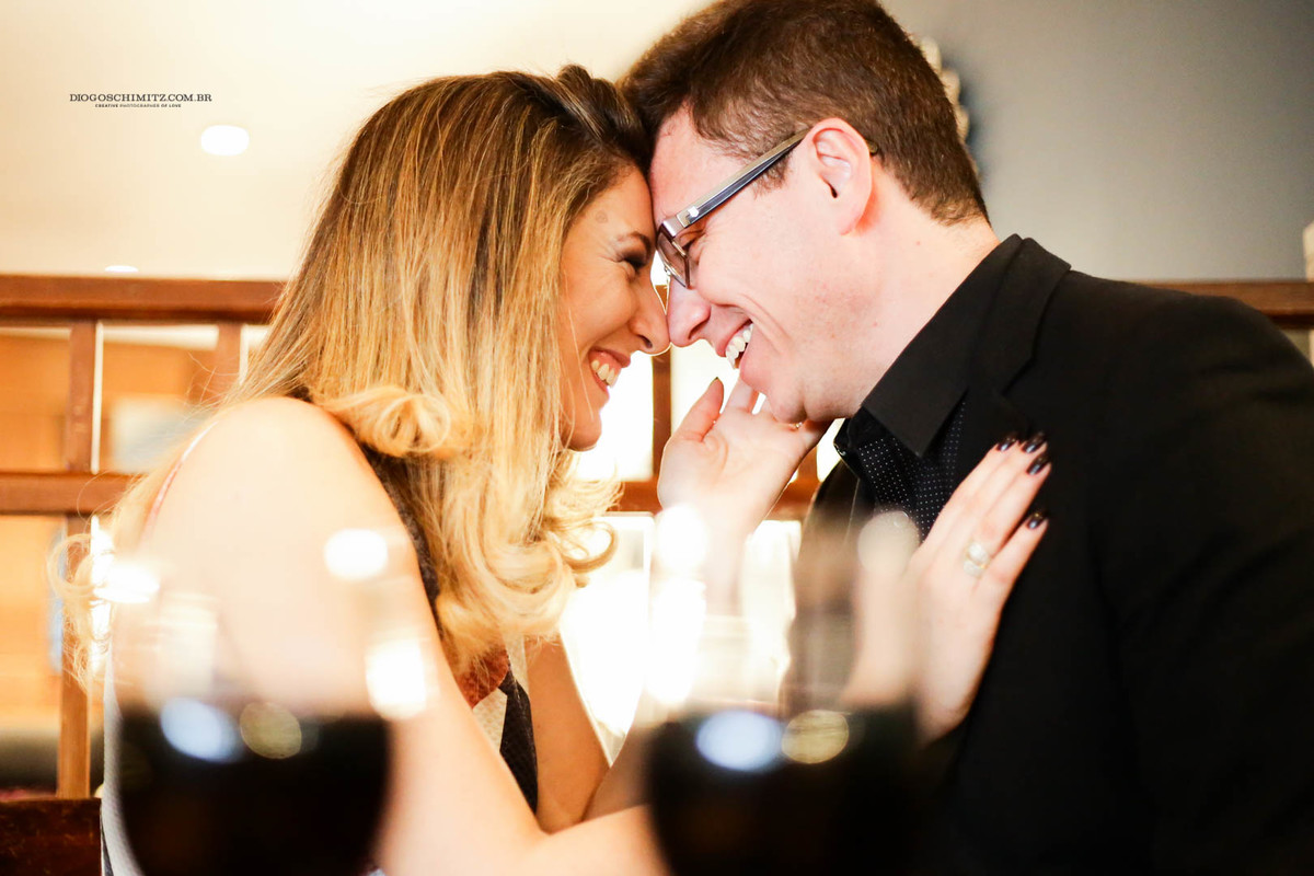 Casal se divertindo e sorrindo em um restaurante.