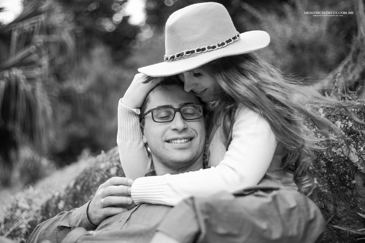 Mulher abraçando o homem enquanto este sorri.