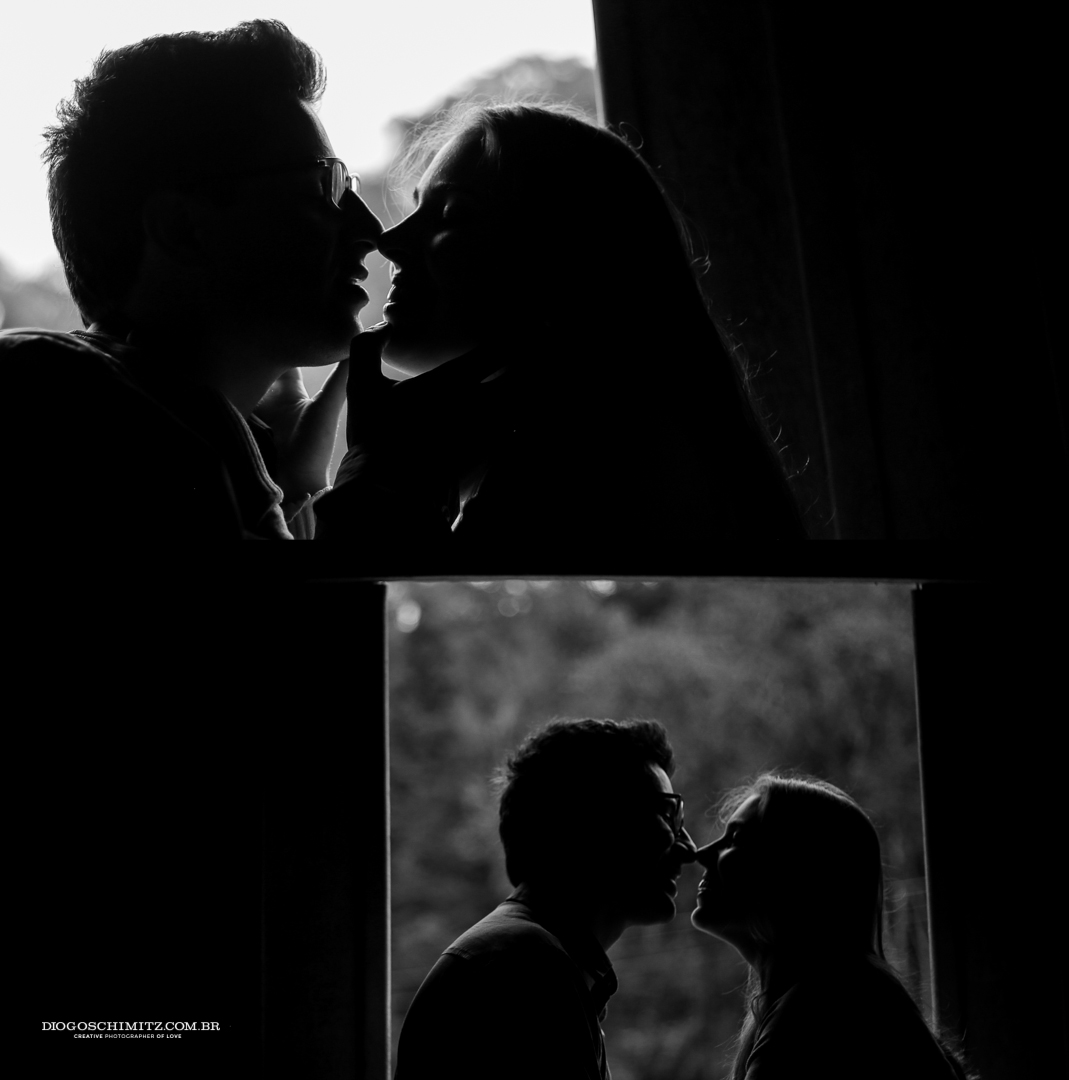 Casal se beijando em frente a uma janela, dessa vez com a foto tirada de dentro.