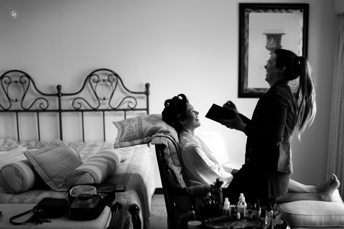 Maquiadora finalizando a maquiagem da noiva.