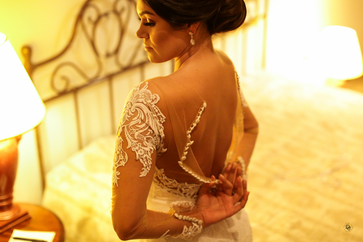 Noiva tentando fechar o vestido .