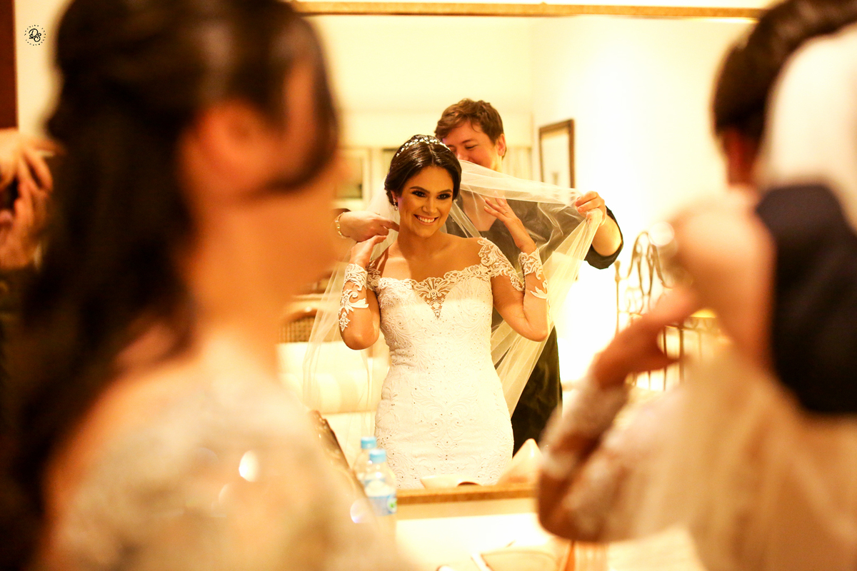 O véu sendo colocado ao lado sua mãe.