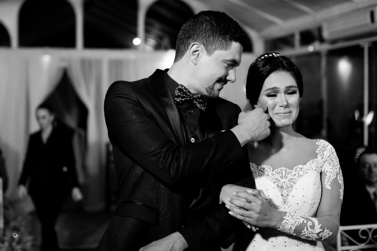 Noiva emocionada e noivo limpando suas lágrimas. 