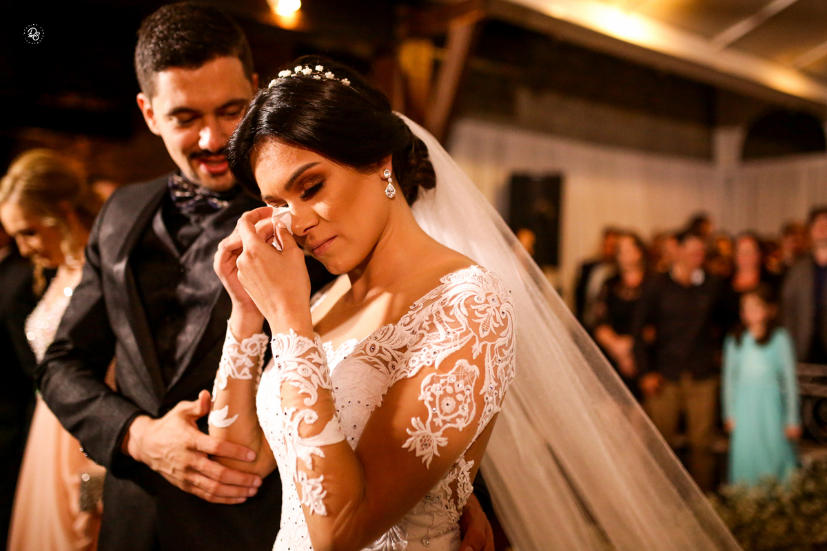 Noiva limpando a lágrima com um lenço. 