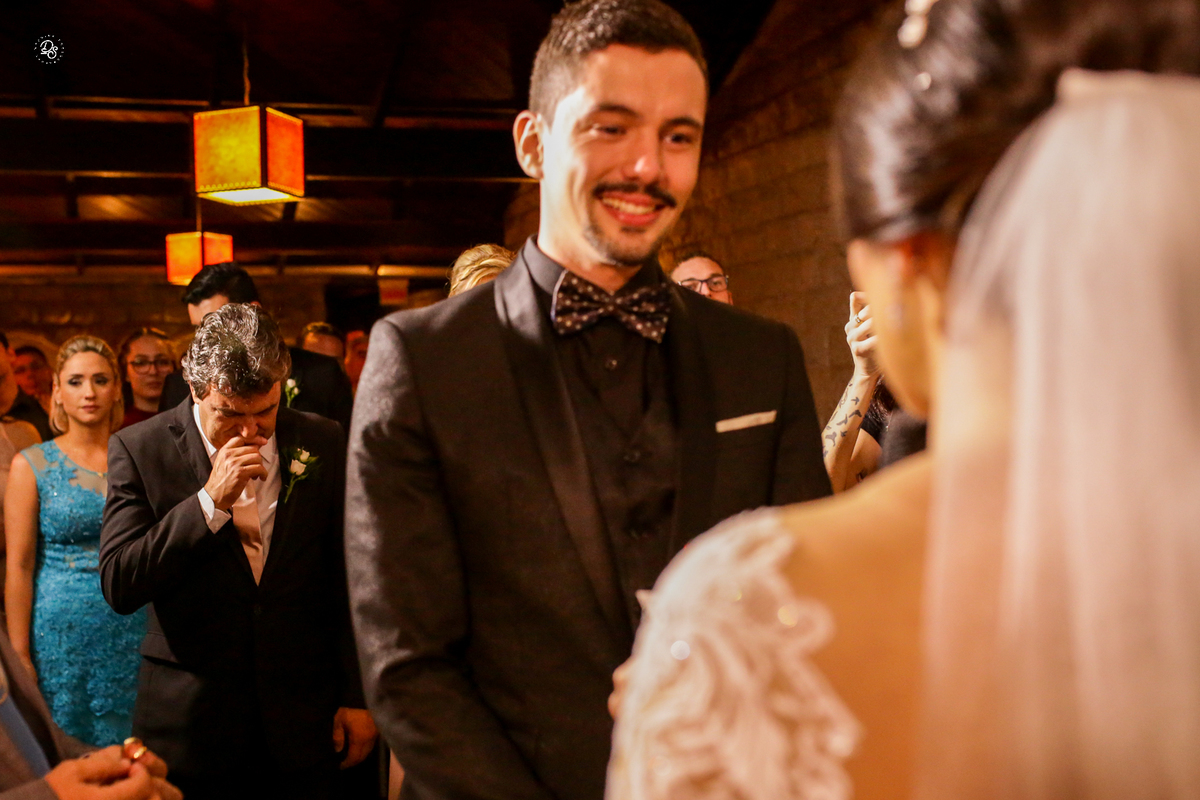 Detalhe do pai do noivo se emocionando ao ver a troca dos votos.