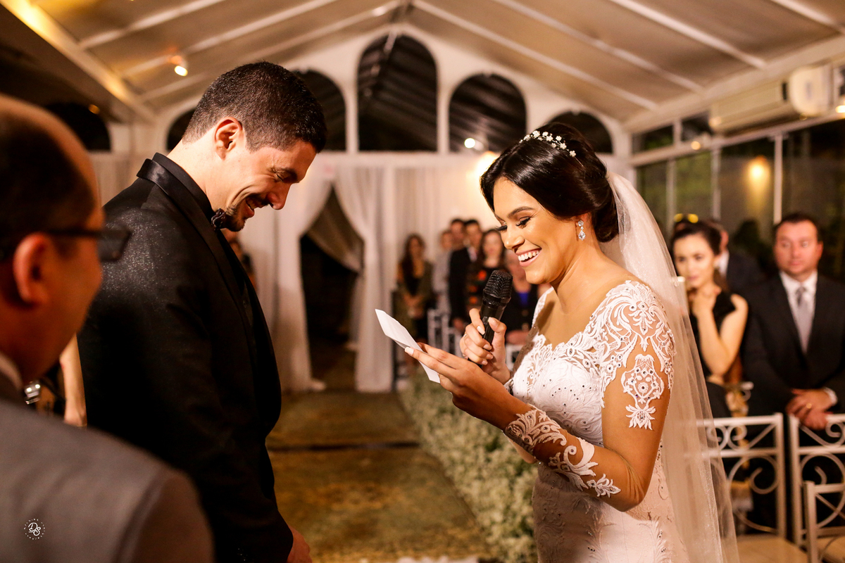 Noivos sorrindo ao trocar votos.