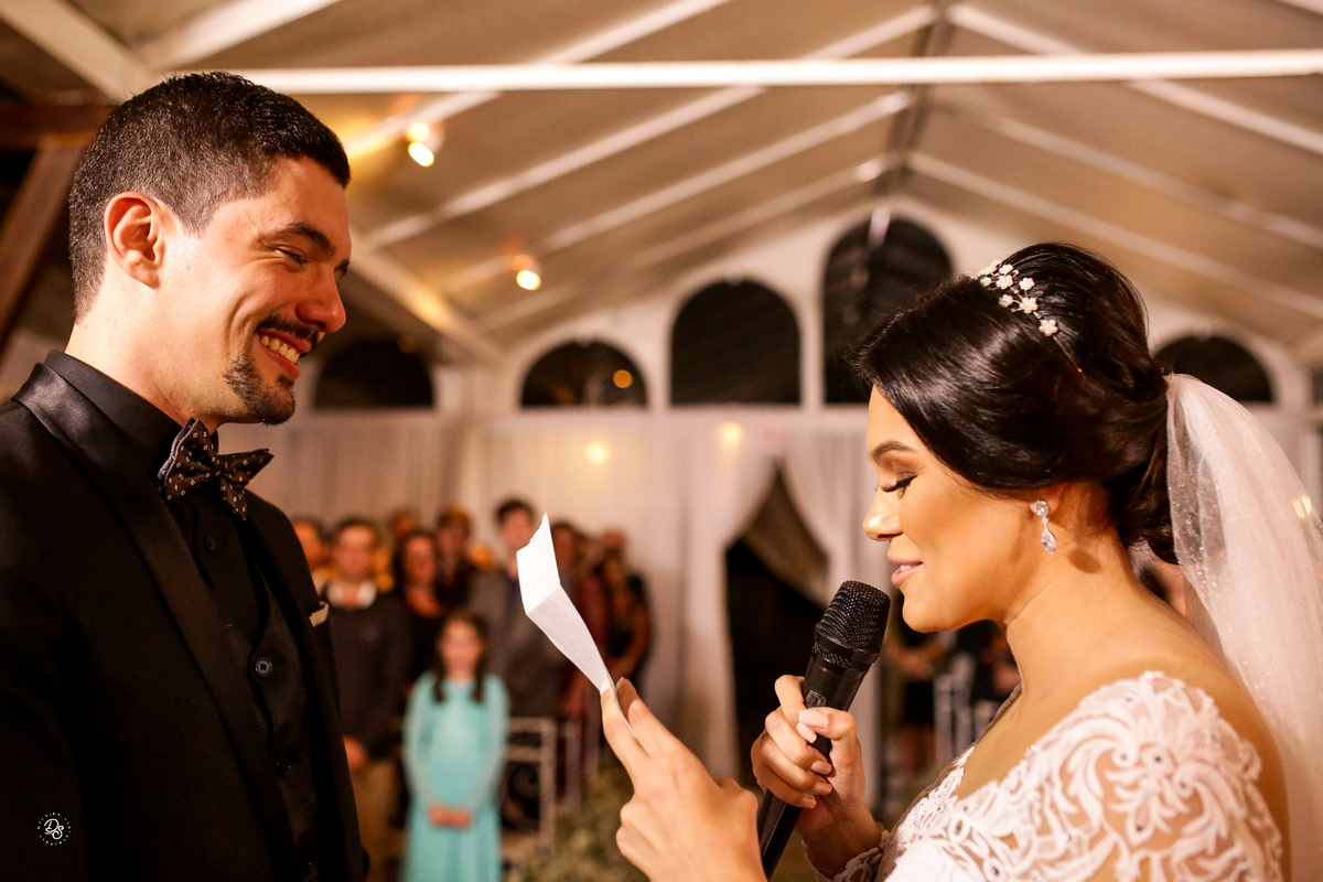 Noivos sorrindo ao trocar votos.