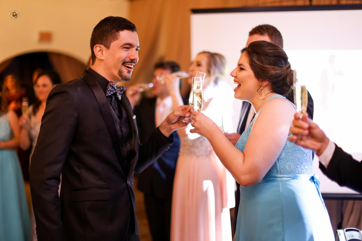 Noivo brindando com os padrinhos ao entrar no salão da recepção.