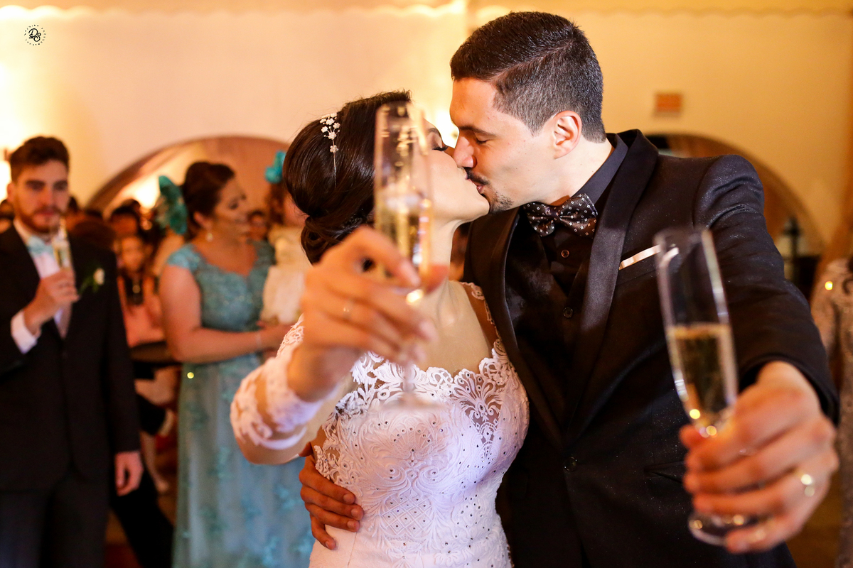 Noivos brindando com os padrinhos ao entrar no salão da recepção.