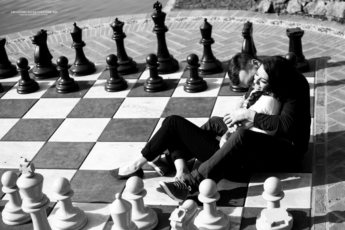 Casal deitado em um tabuleiro de xadrez gigante.