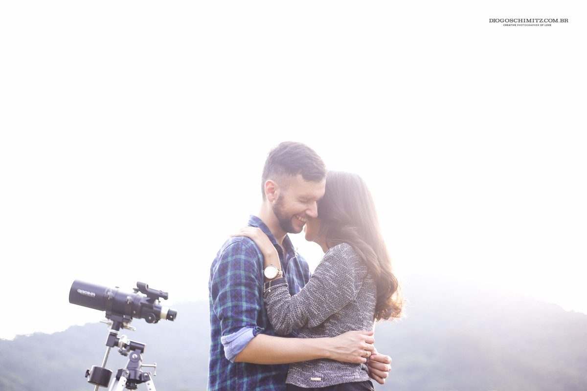 Casal se abraçando e rindo timidamente.