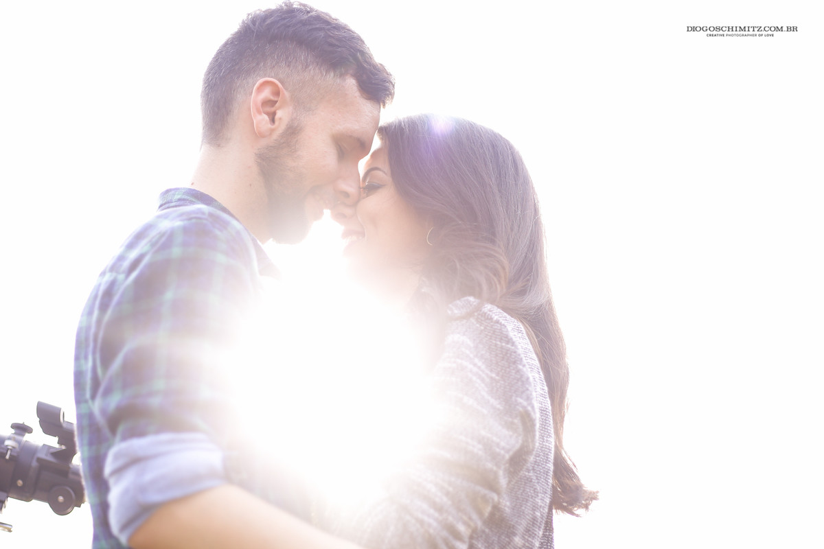 Casal com o rosto proximo um do outro sorrindo.