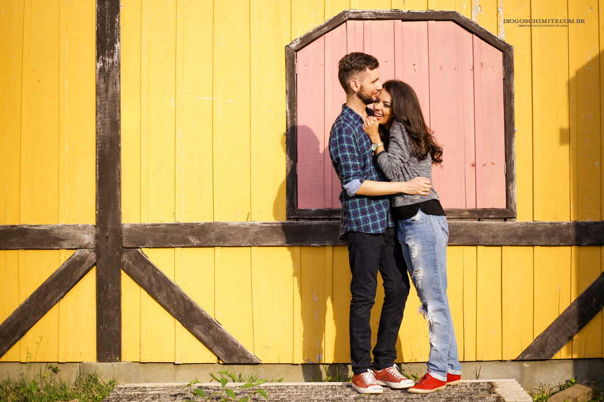 Homem abraçando a mulher enquanto ela ri.