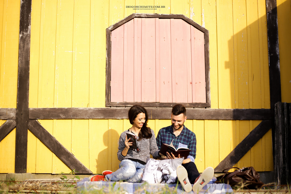 Casal rindo enquanto lêem.