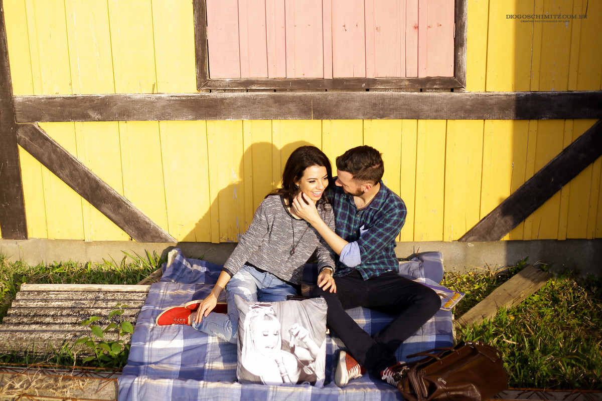 Casal sentado em um edredom xadrez.