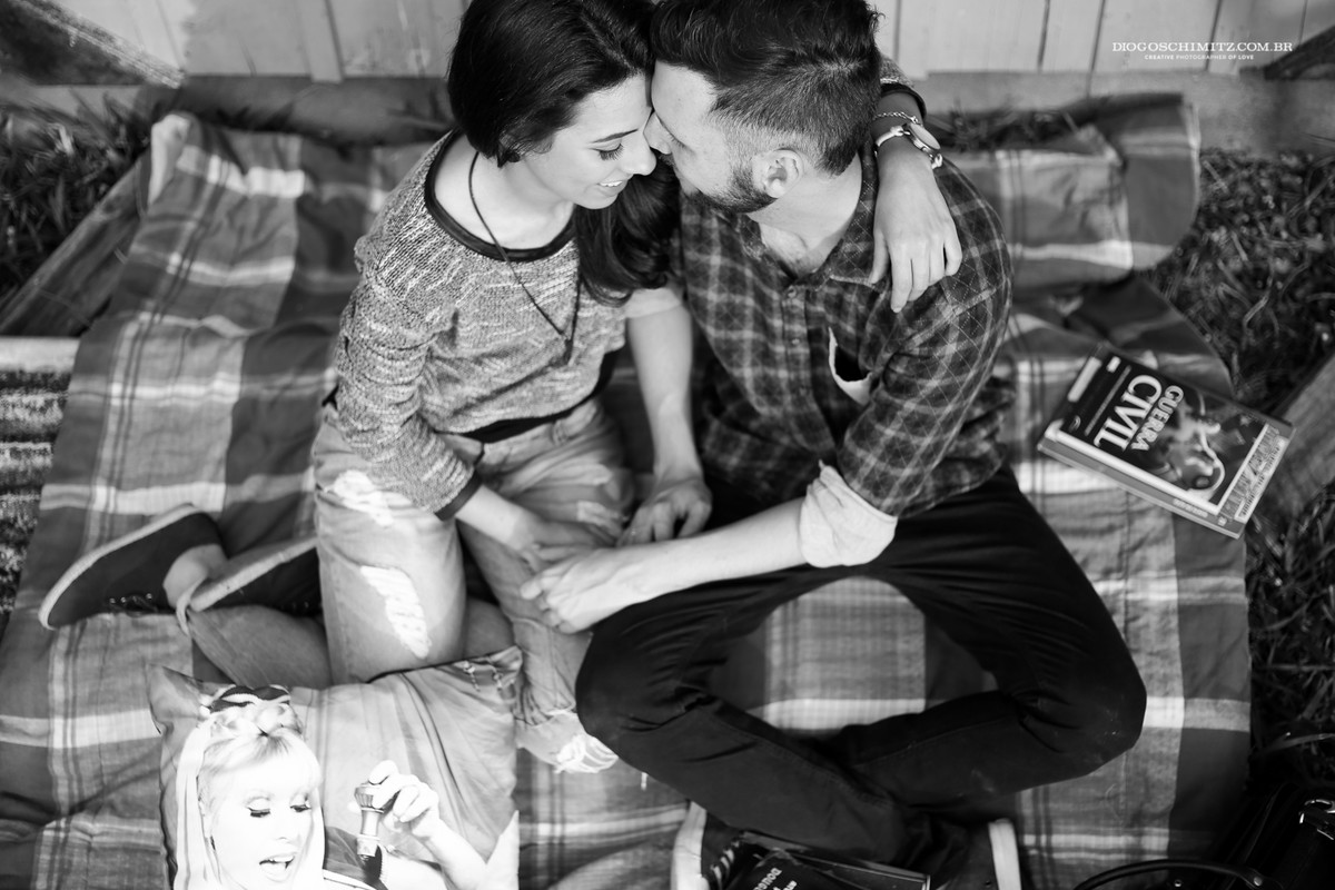 Casal sentado se abraçando timidamente.