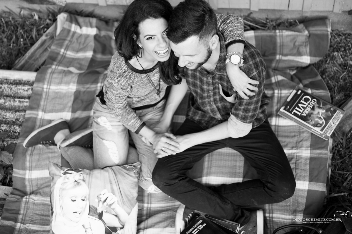 Casal sentado se divertindo enquanto se abraçam.