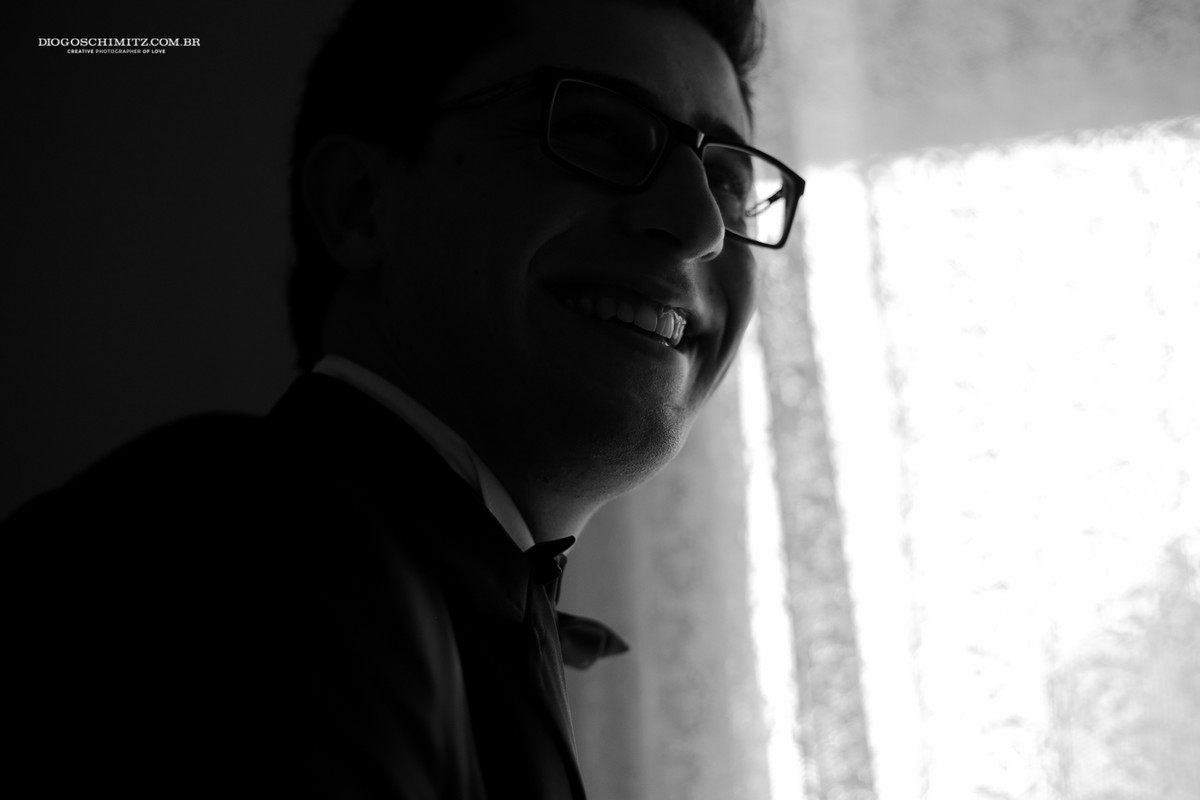 O noivo sorrindo.