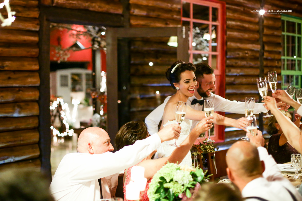 Felicidade da noiva ao brindar com os seus convidados do seu casamento de campo.