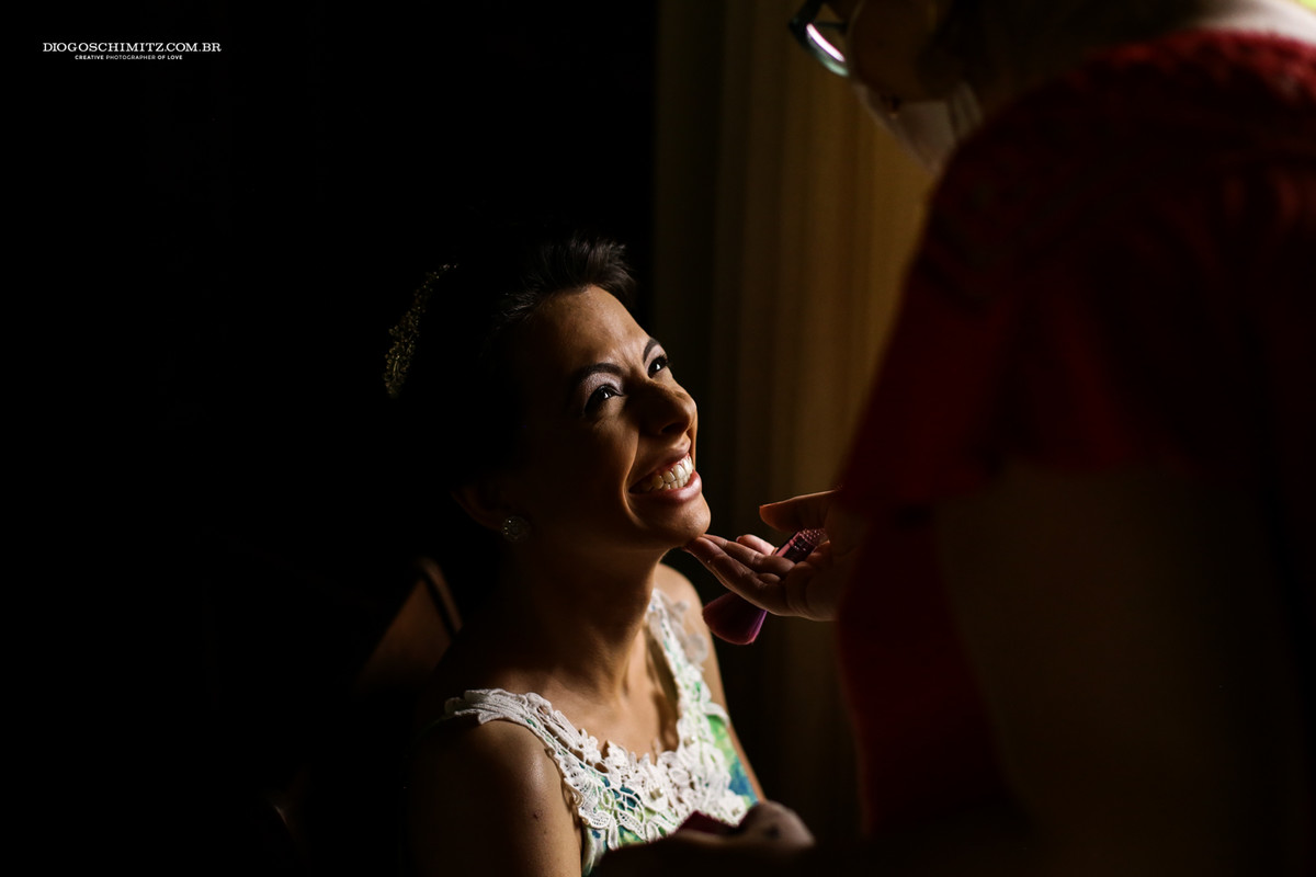 Reação da noiva ao finalizar a sua maquiagem para o seu casamento no campo.